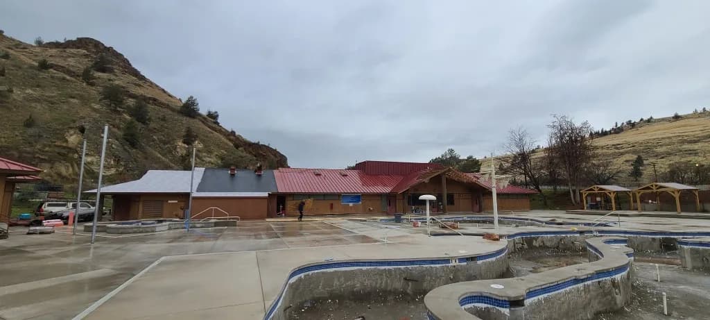 Pool house and clubhouse at Kah-Nee-Ta Resort in Madras, OR, mid-renovation: finished red standing seam, white and black underlayment, drained pools, and Central Oregon hills